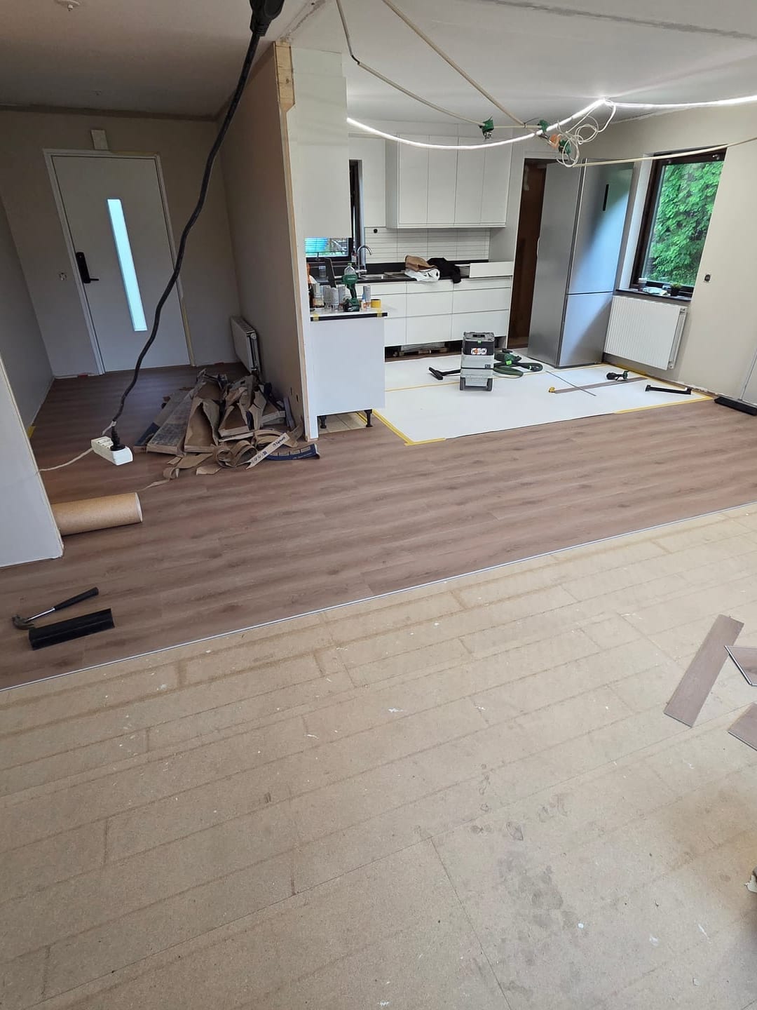 Nytt ljust trägolv under läggning i öppen planlösning