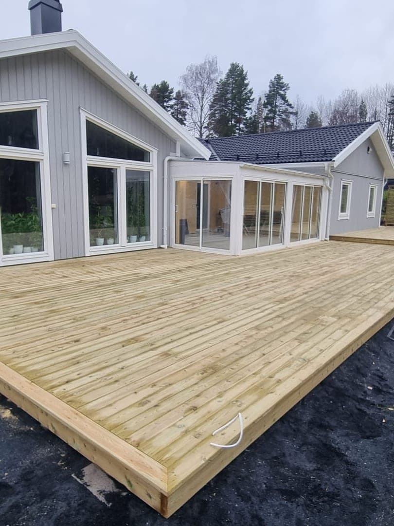 Stor altan runt modernt grått hus